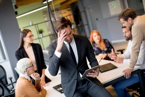 Stressed executive tries to calm nerves in a meeting